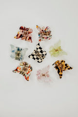 Butterflies fly away but this precious hair claw is guaranteed to keep all your stray hairs perfectly in place and ensure you're perfectly on trend while doing so!   Measures ~ 2" x 1.5" Butterfly shape Classic claw design Pink and green have a marbled design, black has a checkered pattern