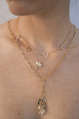 We could not be more in love with this precious banner necklace! With its letters suspended on its thin gold chain, this piece is perfect for everyday wear and can be layered with your other favorites.  Gold Filled Handmade in Costa Mesa, CA. Measures 14" with 2" extender