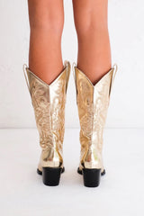 The boot of the season has arrived, and these metallic beauties are made for way more than just walking! The Danilo by Billini is a long western boot that gives the perfect touch of western inspired styling to your everyday, festival, or game day look!   If in between sizes, we recommend sizing up Heel height 7 cm Low stacked block heel Closed pointed toe Structured upper Western inspired embroidery Oversized side pull tabs for a pull on design Synthetic upper, lining and outsole