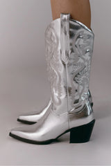 The boot of the season has arrived, and these metallic beauties are made for way more than just walking! The Danilo by Billini is a long western boot that gives the perfect touch of western inspired styling to your everyday, festival, or game day look!   If in between sizes, we recommend sizing up Heel height 7 cm Low stacked block heel Closed pointed toe Structured upper Western inspired embroidery Oversized side pull tabs for a pull on design Synthetic upper, lining and outsole