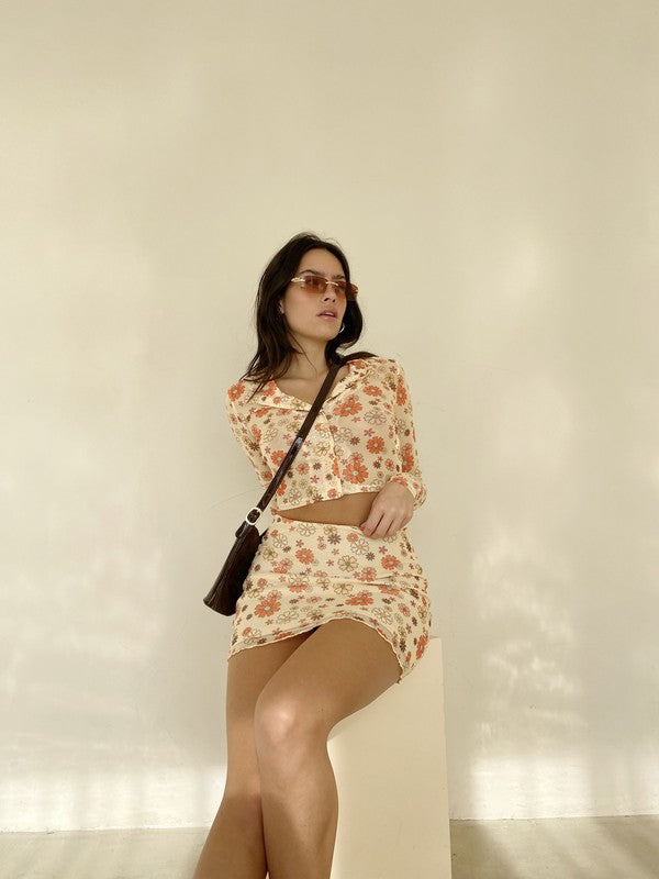 Take a dip in this precious mesh button down! Featuring functional buttons, a collar, and all over groovy daisy print, the styling potential for this gem is truly limitless. Complete the set with our Dippin' in Daisies Mesh Mini Skirt, wear it as a swim cover-up, or throw it on with your favorite denim!  Runs true to size, model wearing size small 95% Polyester, 5% Spandex Unlined Matching item available