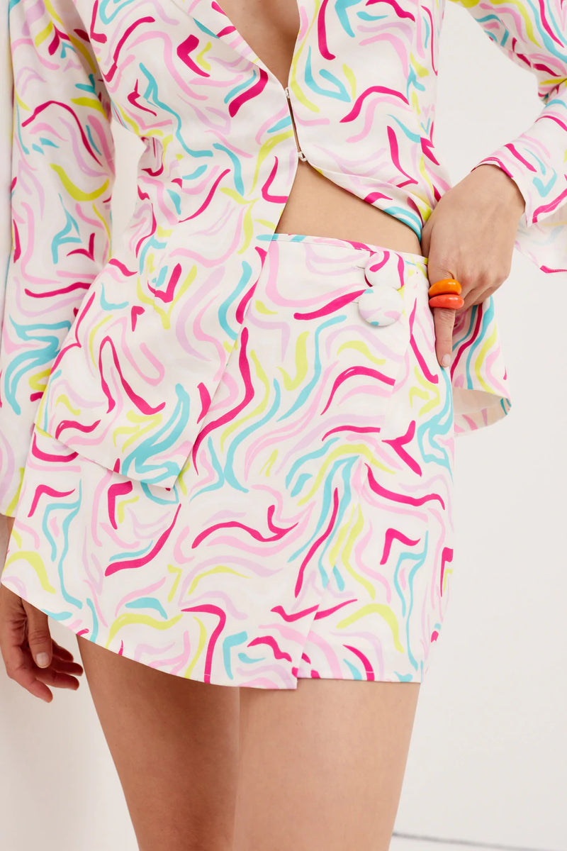 The Noah Mini Skirt is a breezy wrap skirt featuring an 80's-inspired print and oversized tonal buttons. Pairs perfectly with our Noah Top.