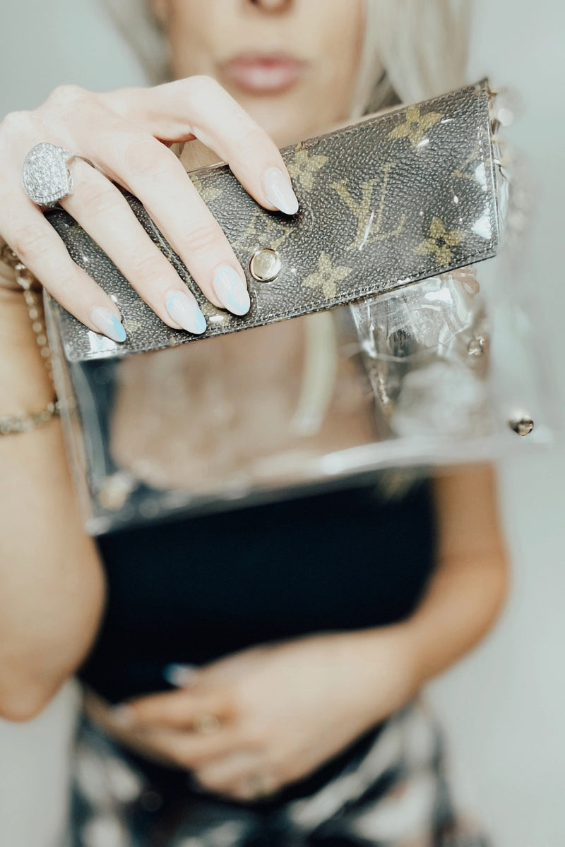 You know you need me. These stadium approved clear bags can be worn as a fanny pack or crossbody and feature an upcycled patch from luxury handbags!  8.5 in x 6.7 in (fits iPhone Pro Max)  Authentic upcycled material from luxury handbags Clear bag policy approved for any and all concerts, games, and indoor arenas 