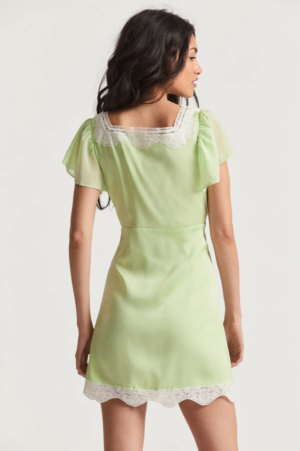 For the flirty and feminine, our Aubrietta Dress from LoveShackFancy makes its dreamy debut. This romantic mini is designed with a solid iteration of combining chiffon fabric with custom contrasting lace on our whimsical charmeuse fabric. Lace highlights the dress outlining an open square scoop neck and lining the hem around a beautiful slit. The piece has playful flutter sleeves for a light and airy feel. 