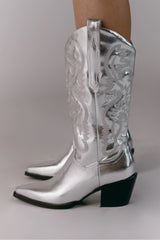 The boot of the season has arrived, and these metallic beauties are made for way more than just walking! The Danilo by Billini is a long western boot that gives the perfect touch of western inspired styling to your everyday, festival, or game day look!   If in between sizes, we recommend sizing up Heel height 7 cm Low stacked block heel Closed pointed toe Structured upper Western inspired embroidery Oversized side pull tabs for a pull on design Synthetic upper, lining and outsole