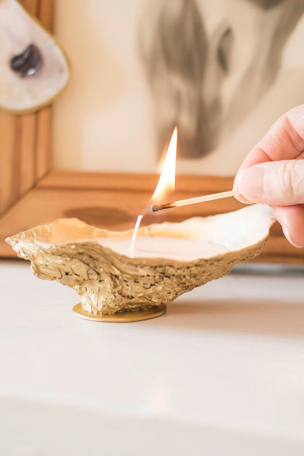 Celebrate the coast by adding these oyster shell candle to your nautical centerpieces and coastal decor. These hand-poured soy wax candles are housed in Grit and Grace Studio's trademark gilded oyster shell dishes, making them an eye-catching, luxurious addition to your home decor. Give an oyster shell candle - or three! - to the ones you hold closest.
