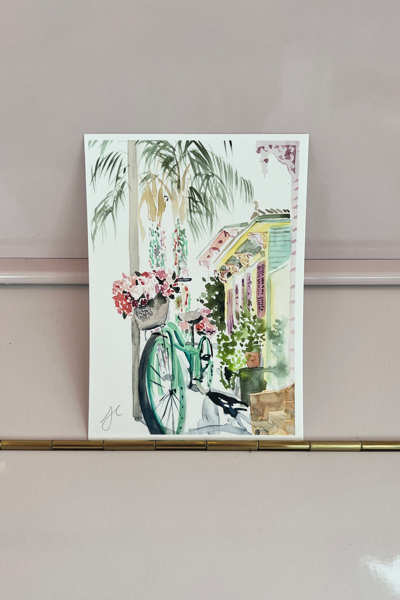 Painted in delicate watercolor on a clean white background by local New Orleans artist Lyla Clayre, this Bicycle in the Marigny print is the perfect gift for any NOLA lover! Grab a few and make your very own collage of New Orleans.  Hand signed 5" x 7" archival quality fine art print Packaged with post-consumer 100% recycled backing board and clear protective sleeve Made in New Orleans