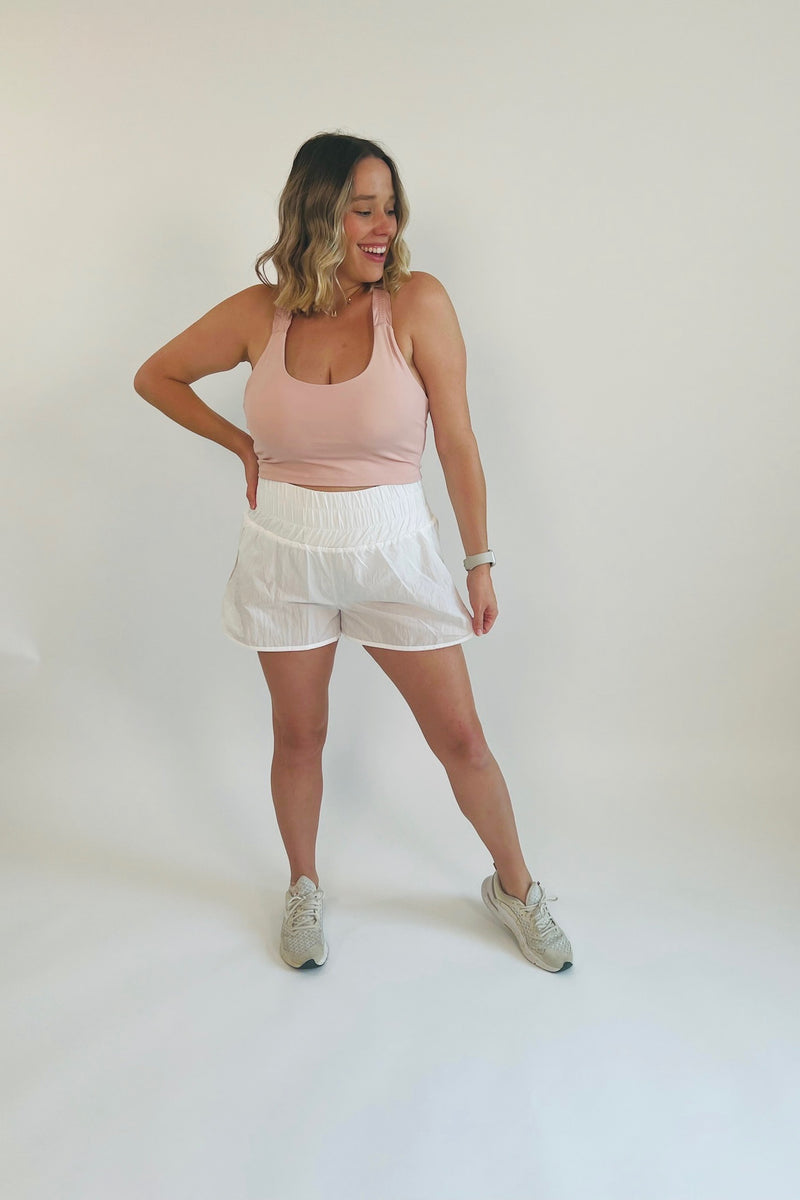 Take a break in these perfectly precious and totally on trend smocked windbreaker shorts! Ultra lightweight, breathable and born for anything and everything from working out to your day out, these are truly the active shorts of the season! Paired with our Prim and Proper Ruffle Sports Bra and Less is More Side Slit Tank.  Runs a little small, Bonnie is 5'5" wearing size large 100% Nylon Side slit High Waist Brief lining
