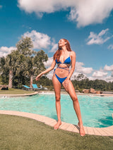 A little wild at heart, this strappy, tie bikini is our new go-to staple for the summer! Featuring metal heart decals at the bust and hips, a classic, adjustable triangle top and side-tie bottom and an edgy and sultry tie detail, this duo gets better as the days get longer.