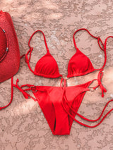 A little wild at heart, this strappy, tie bikini is our new go-to staple for the summer! Featuring metal heart decals at the bust and hips, a classic, adjustable triangle top and side-tie bottom and an edgy and sultry tie detail, this duo gets better as the days get longer.