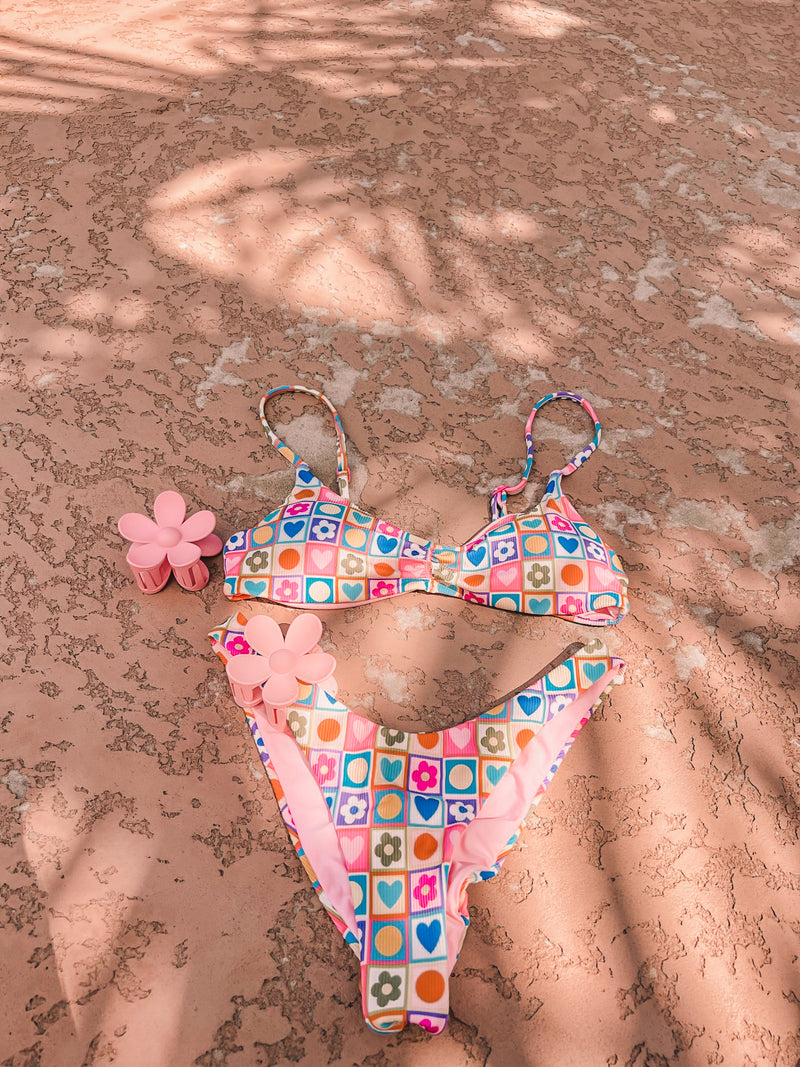 As the queen of hearts, wear your heart on your sleeve and also on your bikini! This precious, retro-printed swimmie is as playful as can be and made for everything the summer holds. Featuring a supportive, sport-friendly top and adjustable straps and a flattering, minimal coverage ruched bottom, this dynamic duo is an instant favorite. 