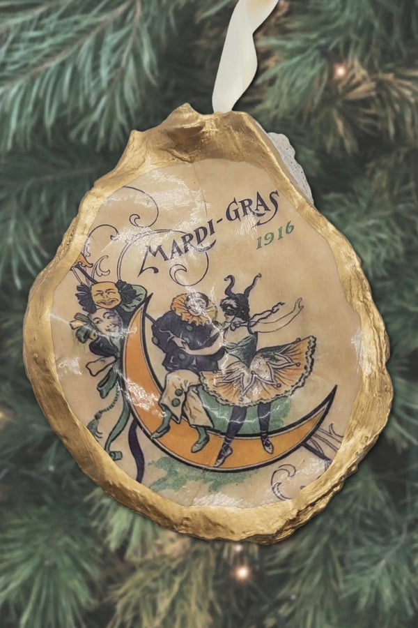 Handcrafted in our very own New Orleans, this beautiful oyster shell ornament features a watercolor Mardi Gras graphic and is the perfect holiday decoration for any and all New Orleans lovers! Let it seamlessly transition your Christmas tree into a Mardi Gras miracle. Meticulously sealed and detailed with golden gilders enamel, then adorned with a metallic ribbon and packaged with an Algiers Oyster Company hang tag. Not to mention ~ they make just about the cutest gift we can imagine!
