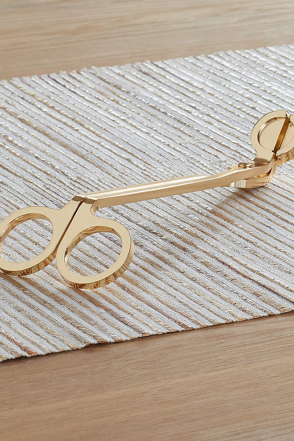 Everyone knows the key to candle life is a well-maintained wick. If you didn't, now you do! Use our lovely brass Wick Trimmer to trim your wicks to 1/4" before each lighting for an even and clean burn. Material: Brass Dimensions: 2.375" L x .125" W x 7" H
